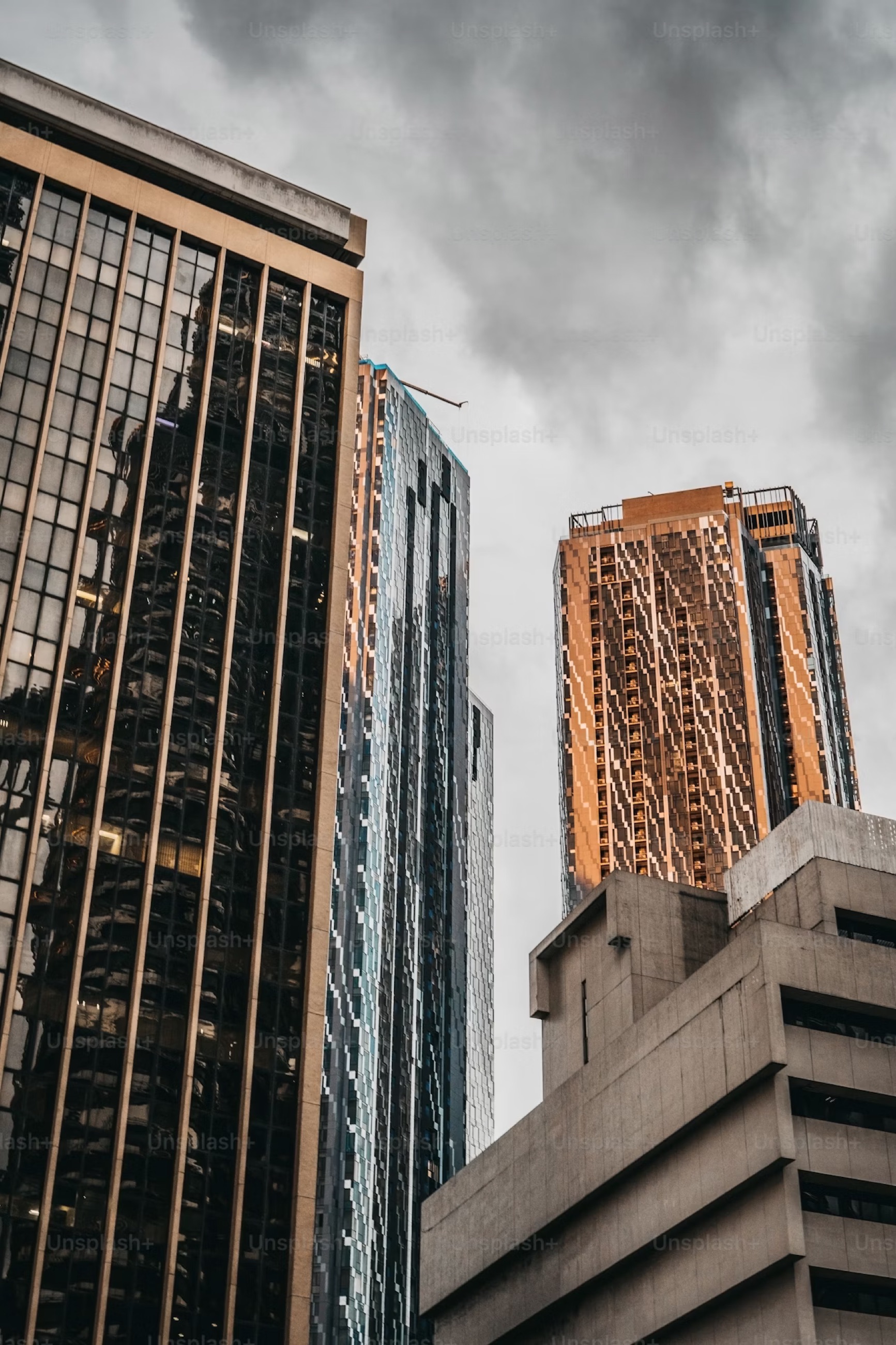 Modern glass office tower against a cloudy sky